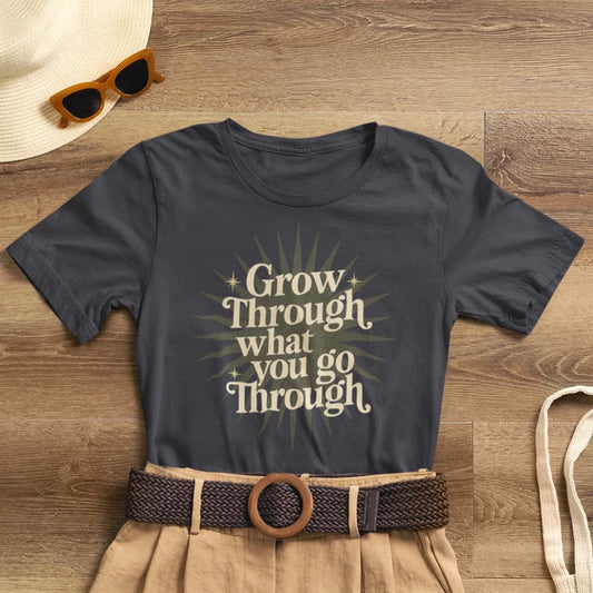 Sunburst motivational graphic T-shirt by Printify featuring the phrase "Grow Through What You Go Through" on a casual cotton tee.