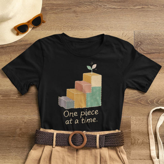 Printify one-piece-at-a-time T-shirt featuring patchwork steps and gentle progress, symbolizing emotional healing.