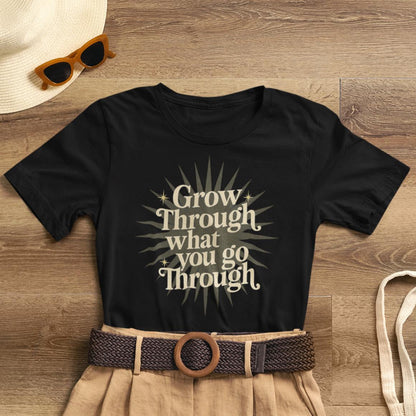 Sunburst motivational graphic T-shirt by Printify featuring the phrase "Grow Through What You Go Through" on a casual tee.