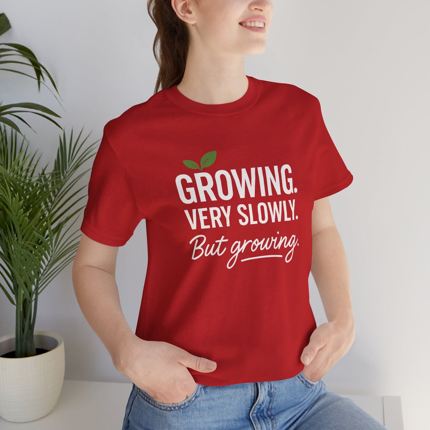 Light-colored T-shirt with the phrase "Growing Very Slowly But Growing" in casual font, emphasizing gentle growth and emotional healing.