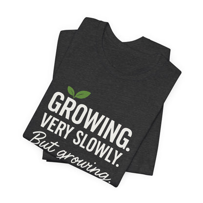 Light grey Growing Very Slowly But Growing T-Shirt by Printify featuring a gentle growth and emotional healing design on soft fabric.