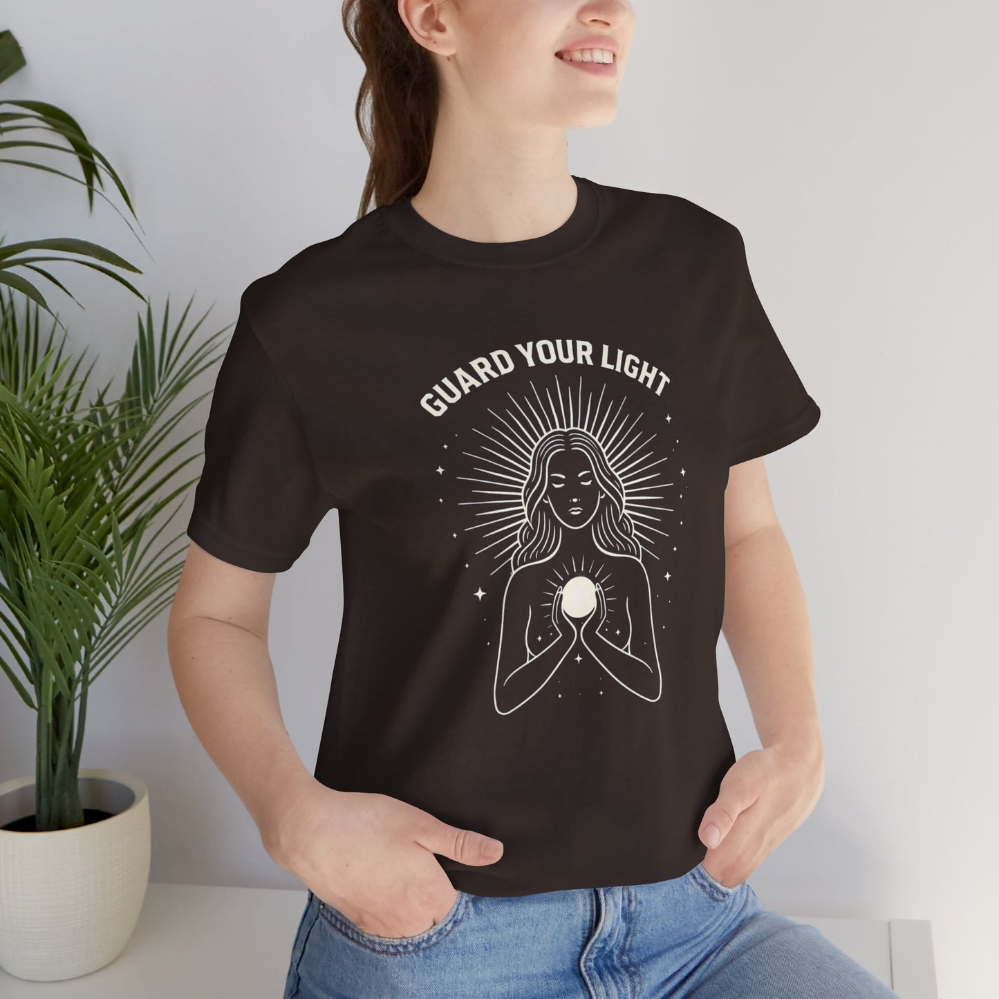 Women’s Guard Your Light T-Shirt by Printify featuring a Sacred Feminine graphic design for spiritual energy protection.