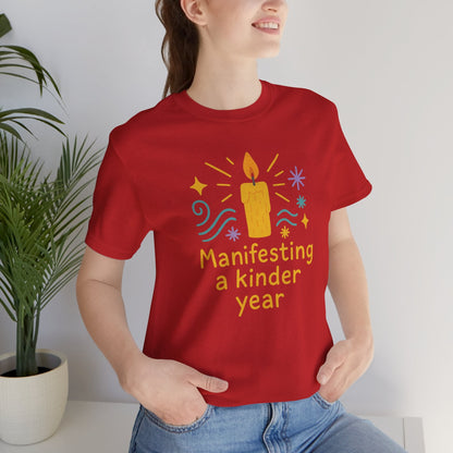 Soft spiritual graphic tee featuring "Manifesting a Kinder Year" design in a mindful, positive message style by Printify.
