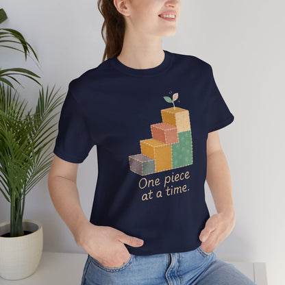 Printify One Piece at a Time T-Shirt featuring patchwork design and gentle progress theme, perfect for emotional healing.