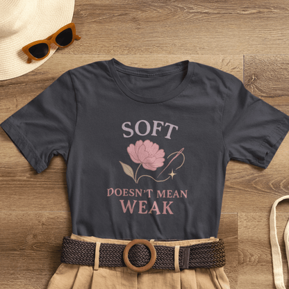 Feminist floral empowerment T-shirt from Printify featuring the "Soft Doesn’t Mean Weak" slogan on a casual tee.