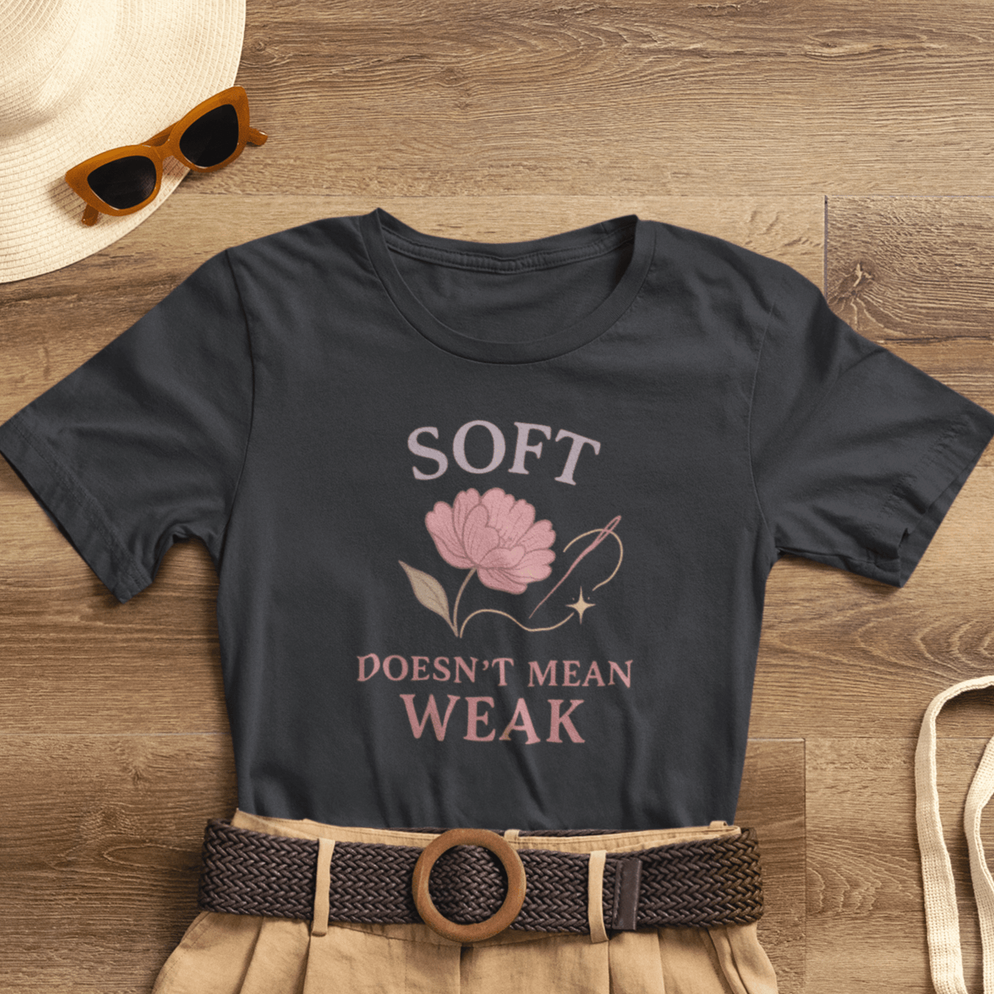 Feminist floral empowerment T-shirt by Printify with bold "Soft Doesn’t Mean Weak" slogan, featuring colorful floral design.