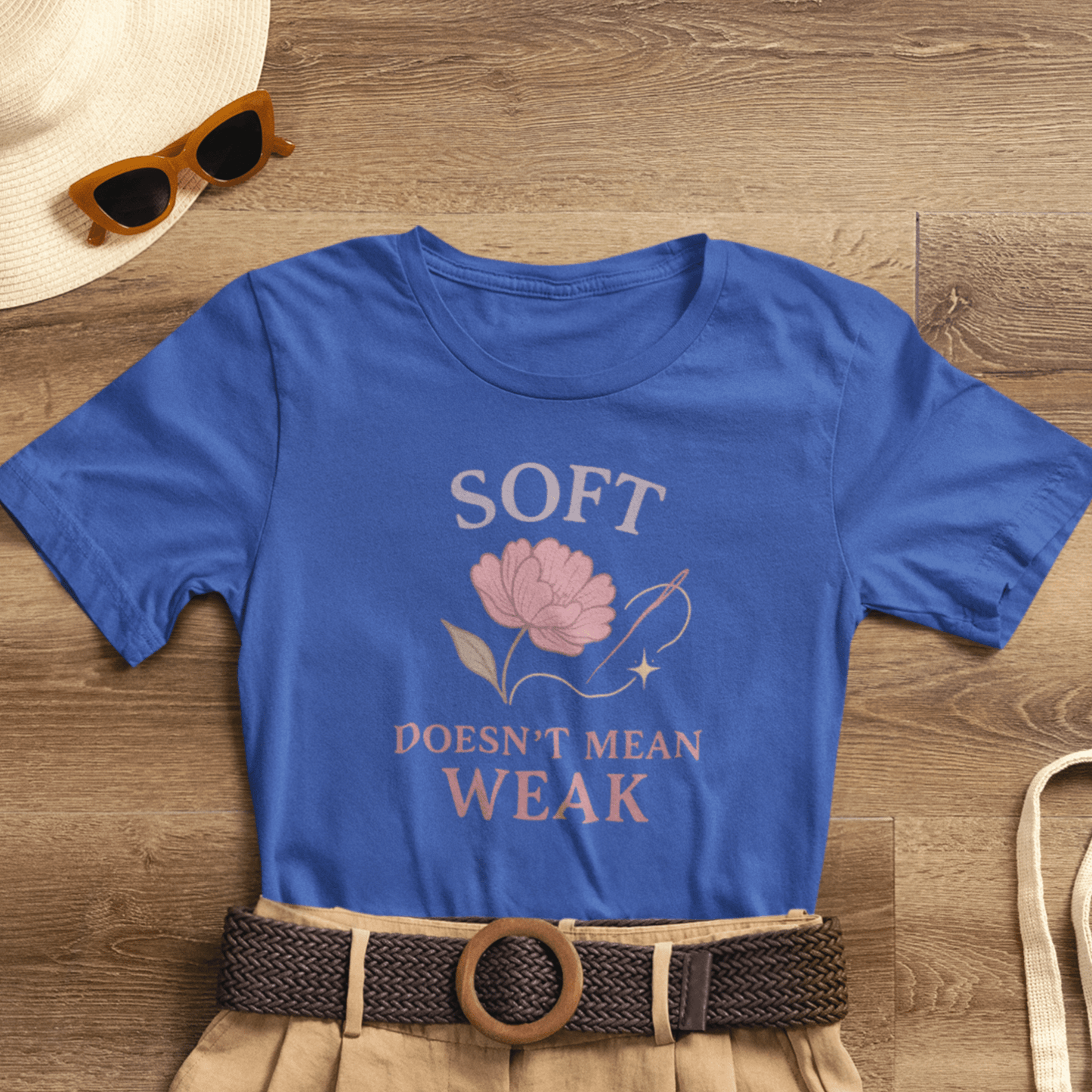 Feminist floral empowerment T-shirt with "Soft Doesn’t Mean Weak" slogan, featuring colorful floral design on a casual tee.