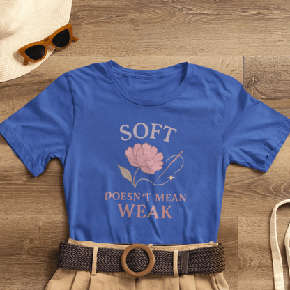 Feminist floral empowerment T-shirt with "Soft Doesn’t Mean Weak" slogan, featuring colorful floral design on a casual tee.