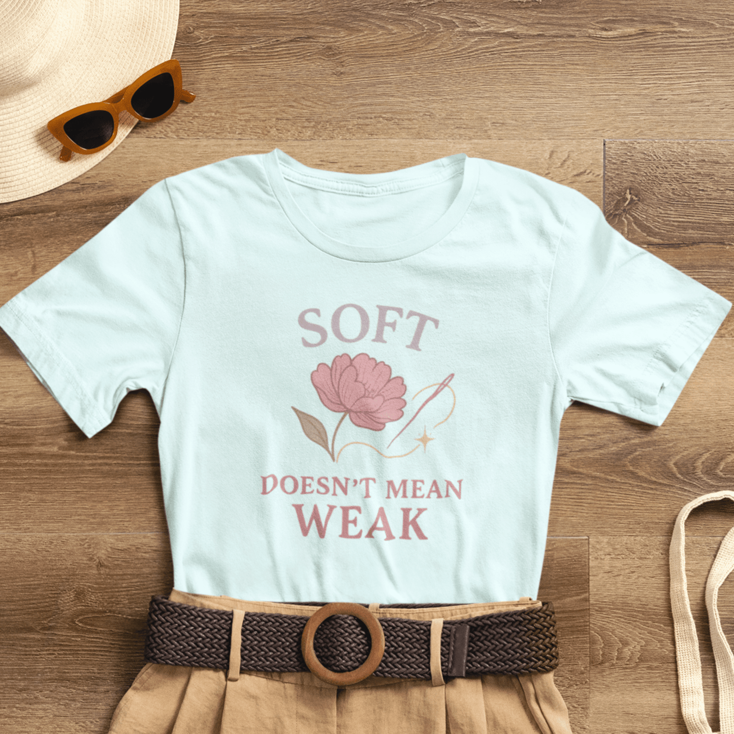 Feminist floral empowerment T-shirt by Printify featuring the "Soft Doesn’t Mean Weak" slogan on a soft, comfortable tee