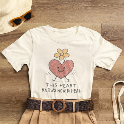 Doodle T-shirt featuring a colorful flower heart design, inspired by "This Heart Knows How to Heal" by Printify.