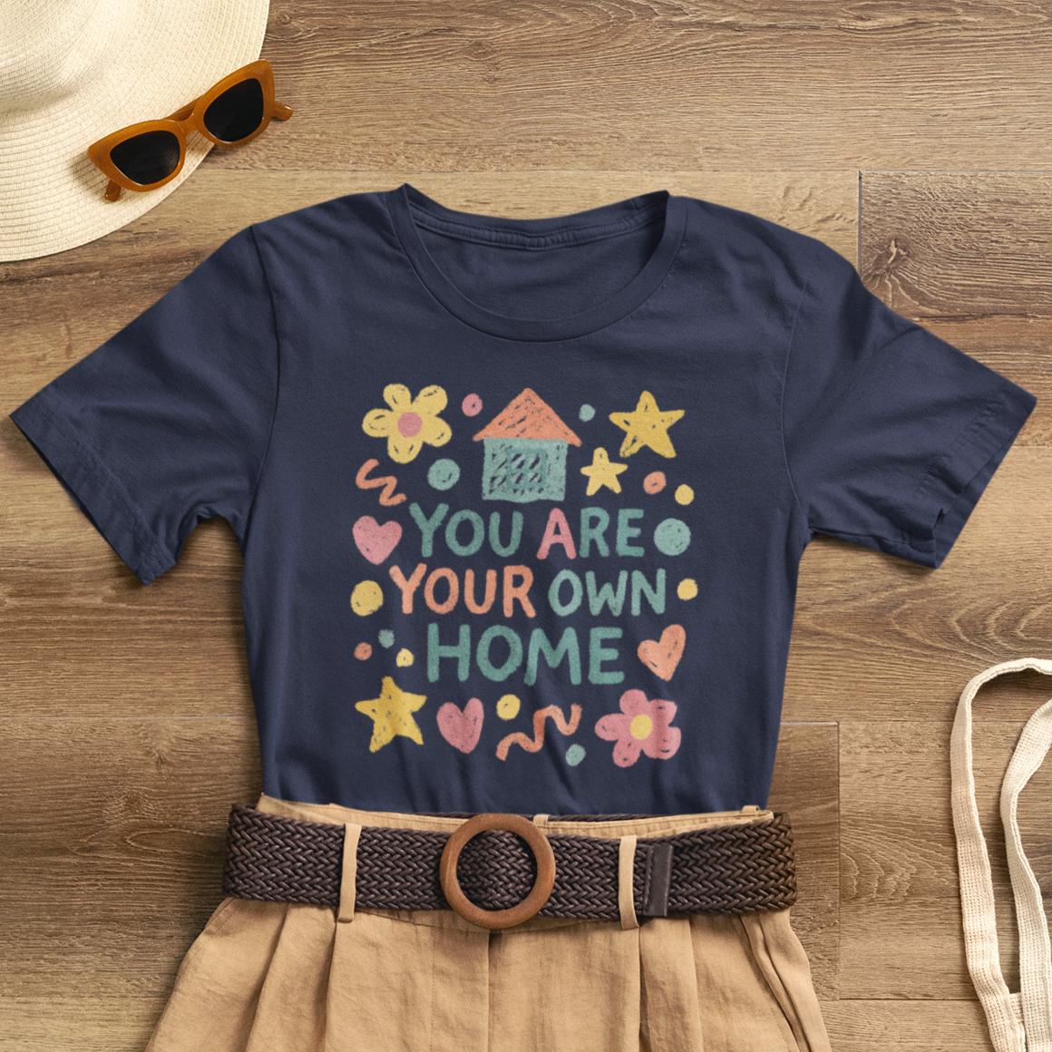 Pastel doodle t-shirt featuring 'You Are Your Own Home' quote, soft fabric, and naive art aesthetic by Printify.