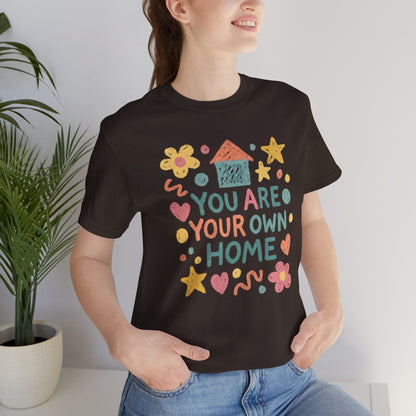 Pastel doodle t-shirt featuring the quote "You Are Your Own Home" in a naive art aesthetic by Printify.