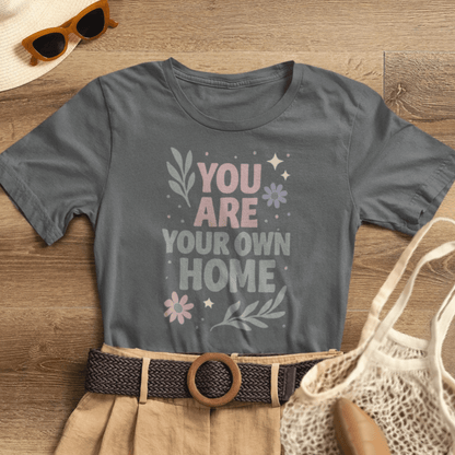 Gray "You Are Your Own Home" T-Shirt by Printify featuring a gentle reminder message for self-love and healing.
